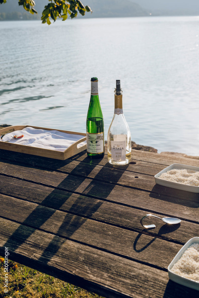 Sarmakinas beim Female Chefs Table am Attersee: Weinflaschen und Reisschalen am Holztisch