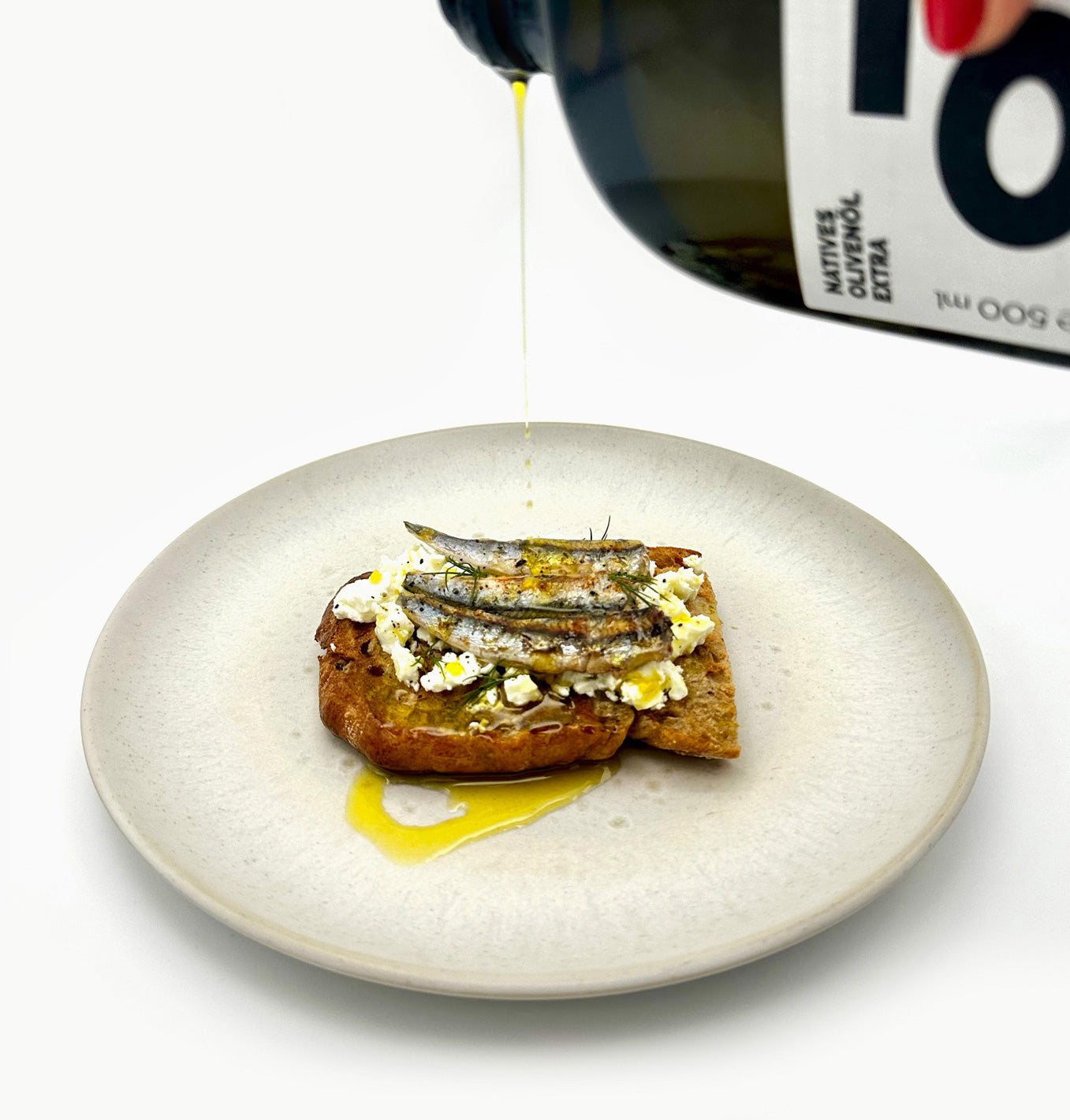 Sarmakinas Zubereitung eines belegten Brotes mit Olivenöl, Feta, Sardellen