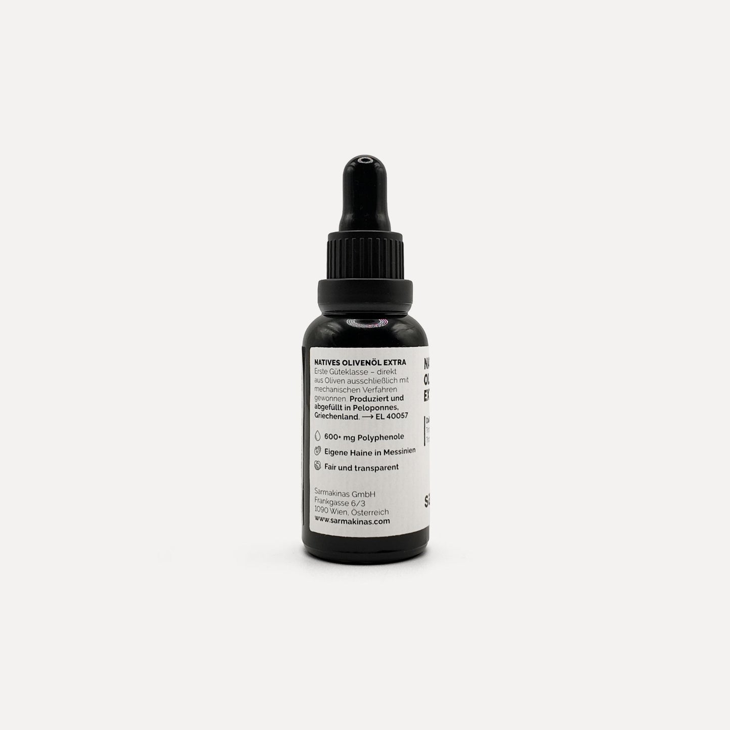 Sarmakinas Daily Drops: 30 ml natives Olivenöl extra in schwarzer Pipettenflasche, sortenreines Koroneiki-Olivenöl, minimalistisch fotografiert vor hellem Hintergrund