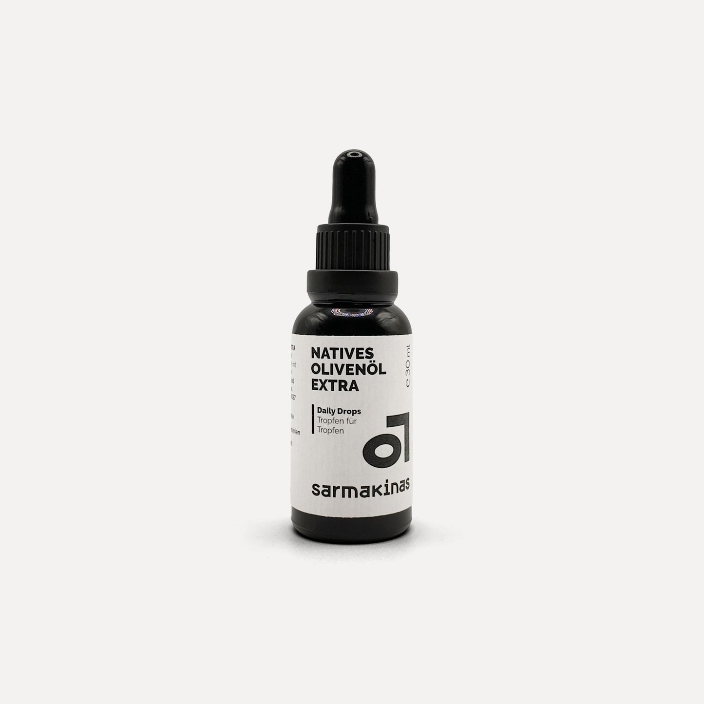 Sarmakinas Daily Drops: 30 ml natives Olivenöl extra in schwarzer Pipettenflasche, sortenreines Koroneiki-Olivenöl, minimalistisch fotografiert vor hellem Hintergrund